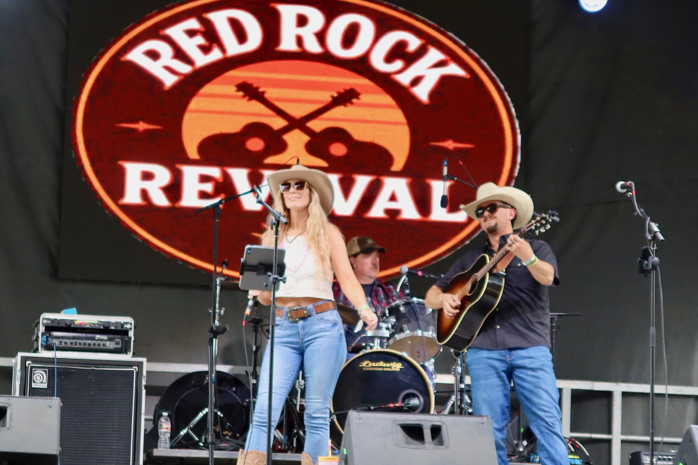 Red Rock Revival on stage beneath their logo — Kristy Lynn singing, Nick Moody on guitar